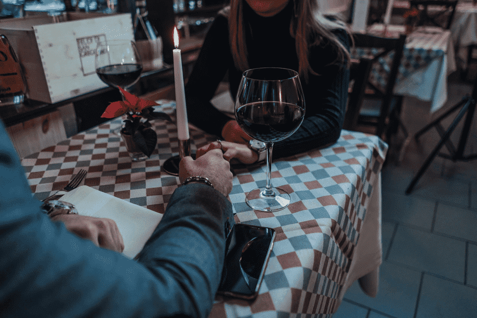 Elite professionals dating in a fancy restaurant while drinking wine